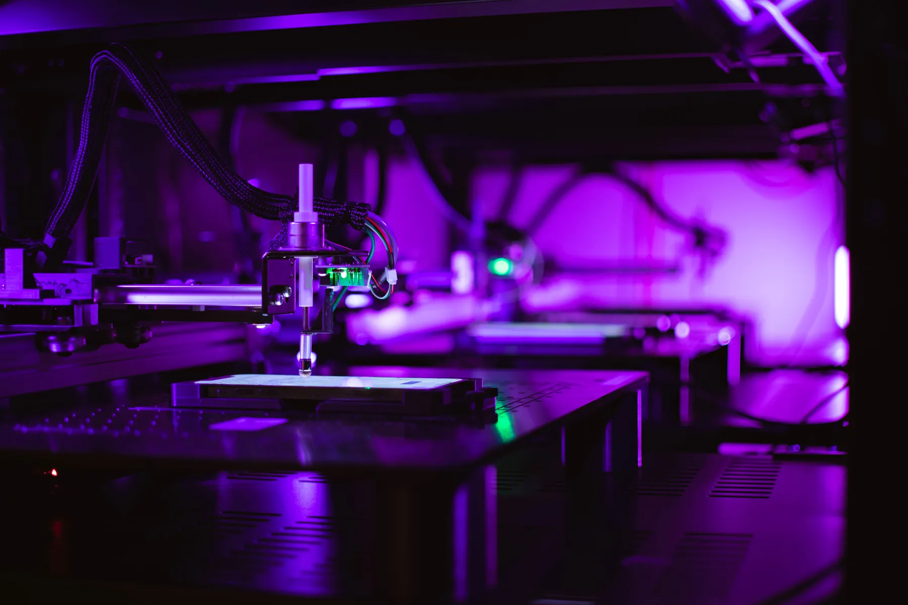 Robot stylus arm poised over a phone on its stage in the Mobot lab